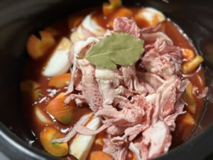 ホットクックにトマトジュースと肉、野菜、ローリエを入れたカレーの材料