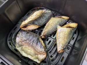 COSORI（コソリ）のバスケットの中で、200度で焼き上がった生のサバ4切れ。皮が破れずパーンと張っている様子